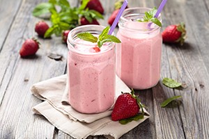 Fruit smoothie with mint leaves on wooden rustic table